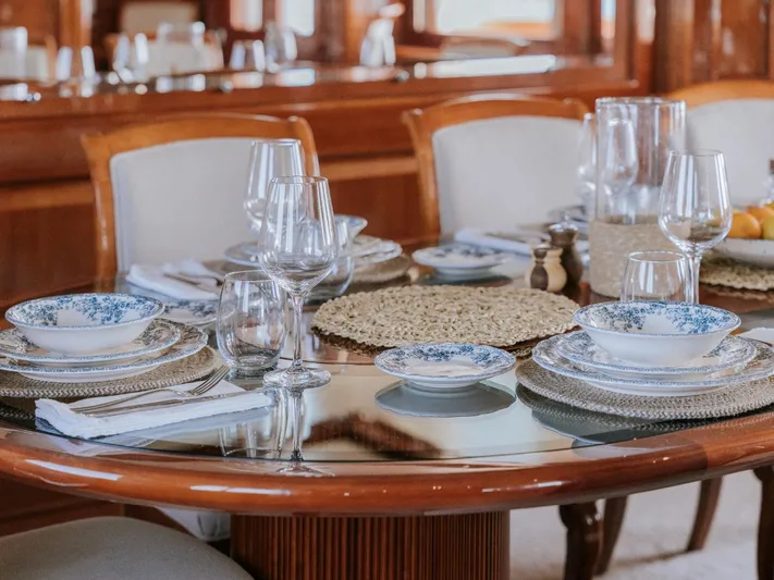 Frienship Yacht Photos Pics Elegant dining setup on Benetti Classic 115 yacht, featuring fine china and glassware.
