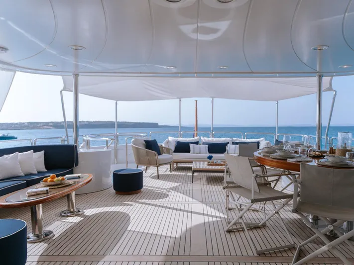 Frienship Yacht Photos Pics Luxurious deck of 2000 Benetti Classic 115 yacht with elegant seating and ocean view.