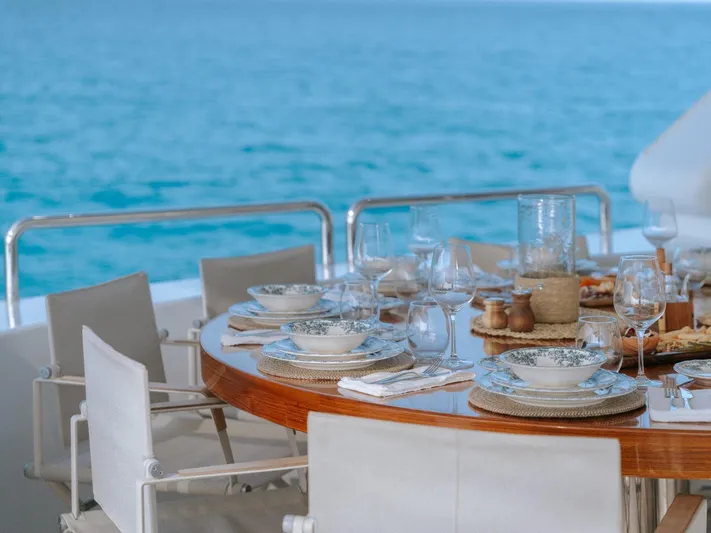 Frienship Yacht Photos Pics Elegant dining setup on Benetti Classic 115 yacht, overlooking serene ocean waters.