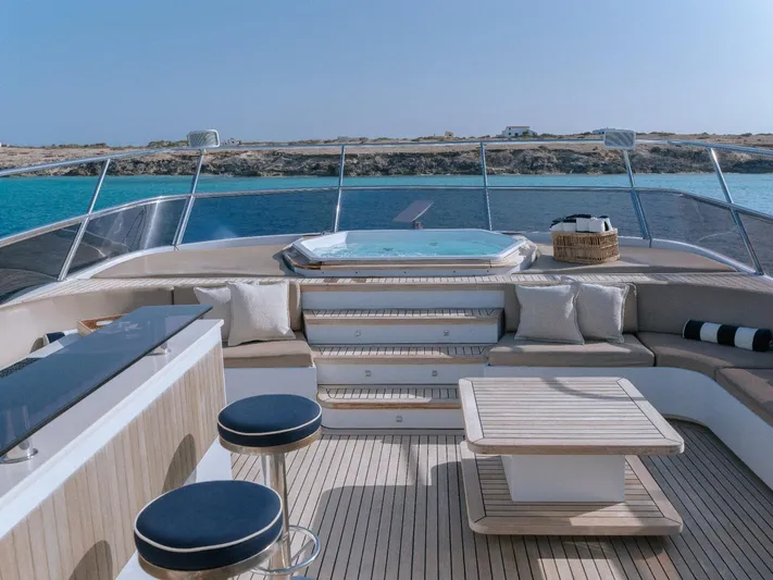 Frienship Yacht Photos Pics Luxurious Benetti Classic 115 yacht deck with seating, table, and jacuzzi, 2000 model.