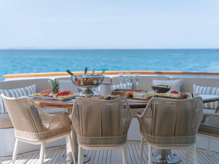 Frienship Yacht Photos Pics Luxurious dining setup on Benetti Classic 115 yacht, overlooking serene ocean view.