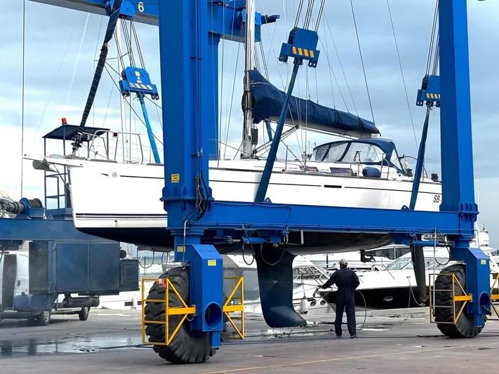 4746 Yacht Photos Pics Dufour 44 Performance yacht being lifted by a blue crane at a marina.