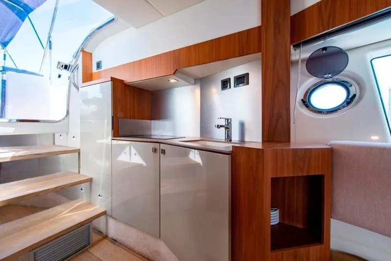 Amaretto Yacht Photos Pics Modern kitchen area in 2015 Absolute 40 STL yacht with wooden cabinetry and stainless steel sink.