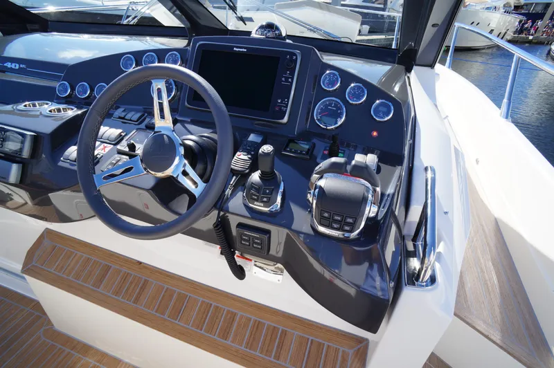 Amaretto Yacht Photos Pics Control panel of a 2015 Absolute 40 STL yacht with steering wheel and navigation instruments.
