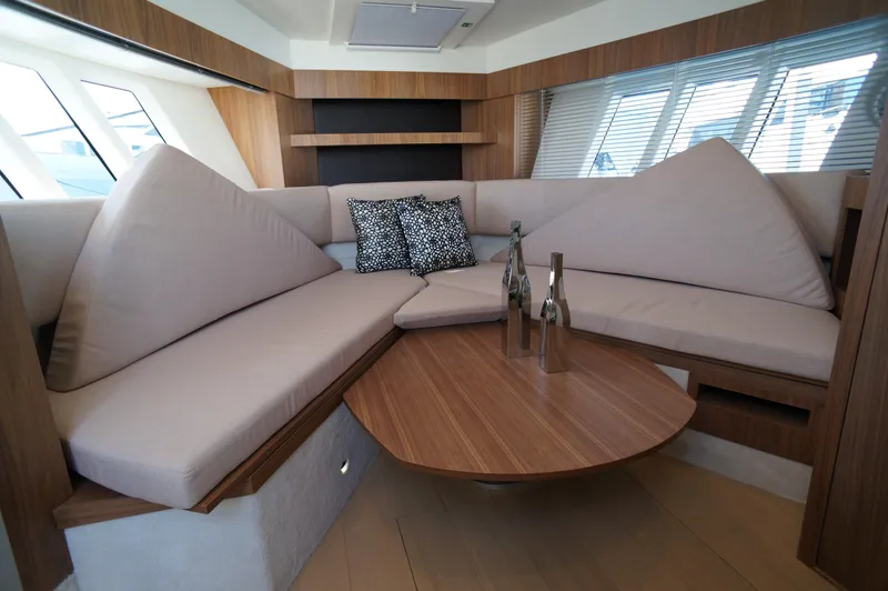 Amaretto Yacht Photos Pics Luxurious interior of 2015 Absolute 40 STL yacht with modern seating and wooden table.