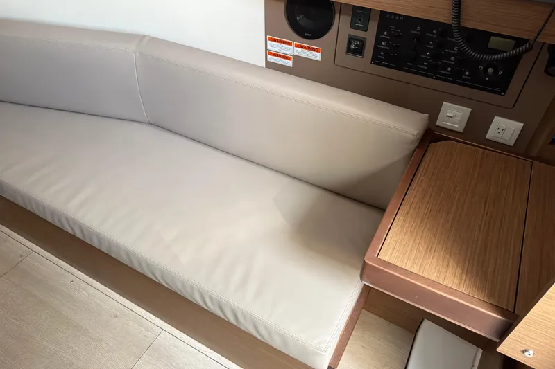  Yacht Photos Pics Interior of 2021 Beneteau Oceanis 35.1 yacht with beige seating and control panel.