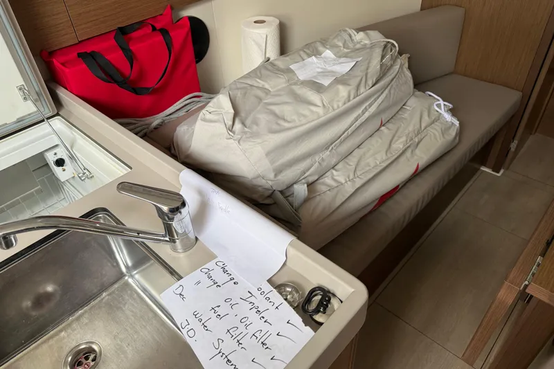  Yacht Photos Pics Interior of 2021 Beneteau Oceanis 35.1 with sink, red bag, and folded sail.