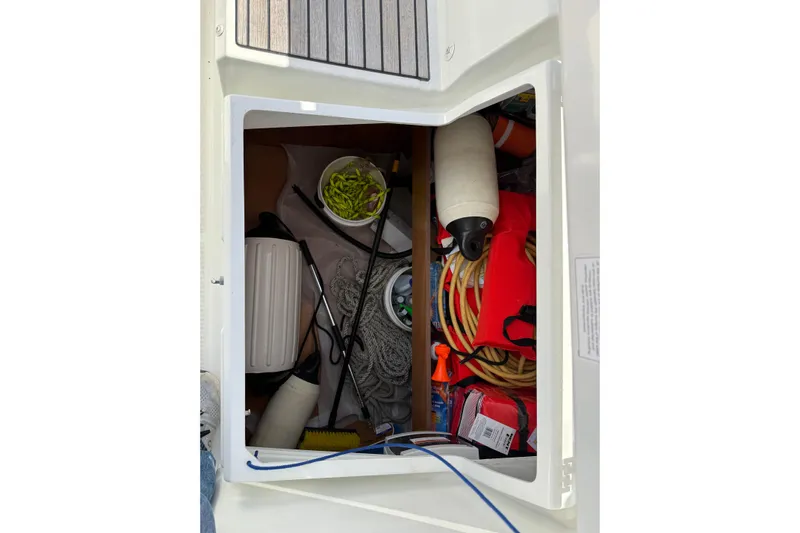 Yacht Photos Pics Storage compartment of a 2021 Beneteau Oceanis 35.1 sailboat with various boating equipment.