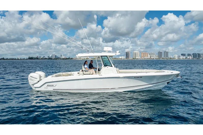 330 Boston Whaler Yacht Photos Pics 2017 Boston Whaler 330 Outrage boat on water, city skyline in background.