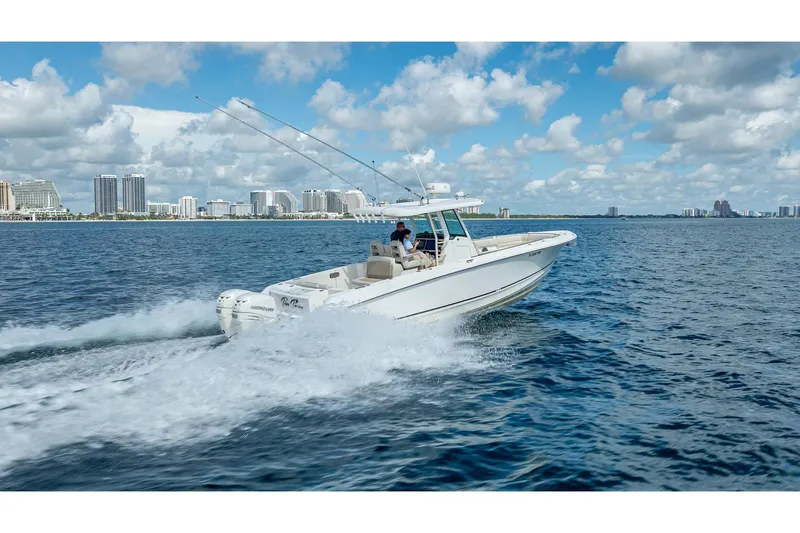 330 Boston Whaler Yacht Photos Pics 2017 Boston Whaler 330 Outrage cruising on open water with city skyline in background.