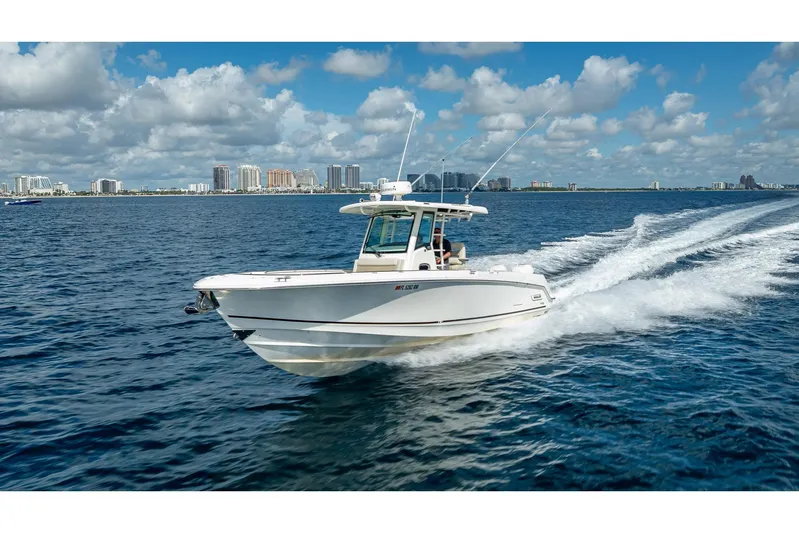 330 Boston Whaler Yacht Photos Pics 2017 Boston Whaler 330 Outrage cruising on open water with city skyline in background.