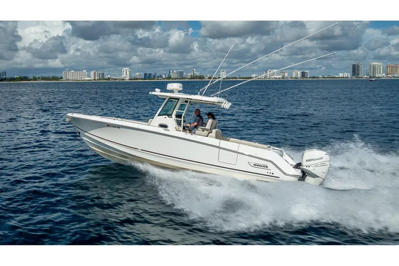 330 Boston Whaler Yacht Photos Pics 2017 Boston Whaler 330 Outrage cruising on ocean near city skyline.