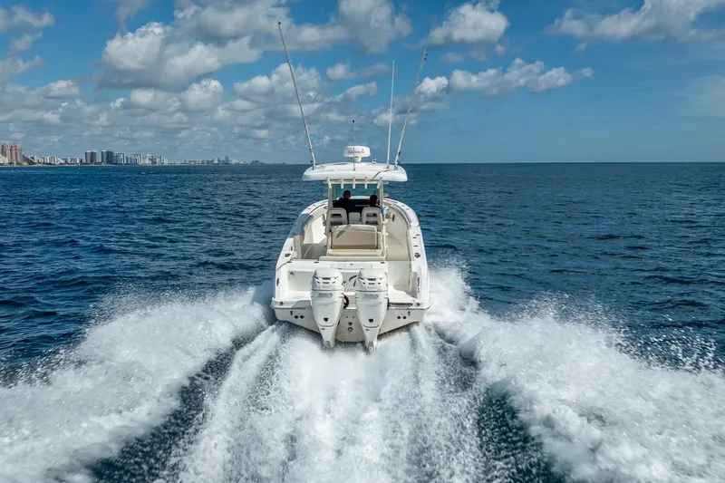 330 Boston Whaler Yacht Photos Pics Boston Whaler 330 Outrage 2017 cruising on open ocean with city skyline in background.