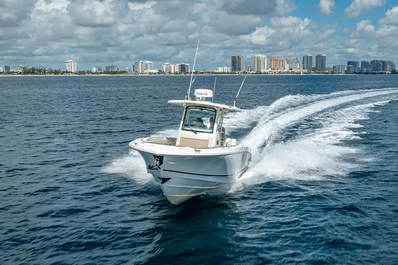 330 Boston Whaler Yacht Photos Pics 2017 Boston Whaler 330 Outrage cruising on ocean near city skyline.