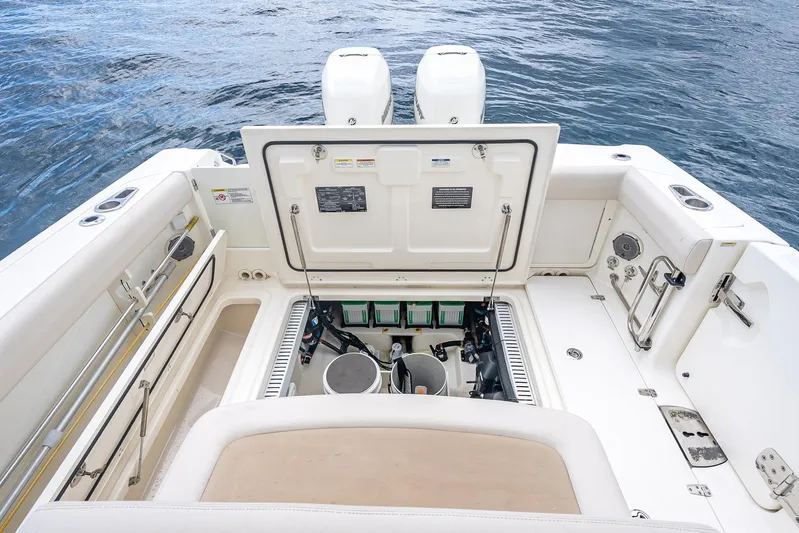 330 Boston Whaler Yacht Photos Pics 2017 Boston Whaler 330 Outrage boat deck with open storage compartment, twin engines visible.