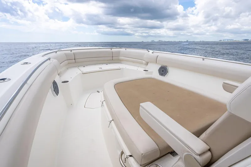 330 Boston Whaler Yacht Photos Pics 2017 Boston Whaler 330 Outrage boat interior with cushioned seating, ocean view, and cloudy sky.