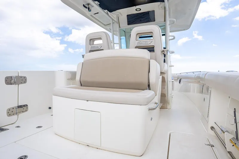 330 Boston Whaler Yacht Photos Pics 2017 Boston Whaler 330 Outrage boat interior with cushioned seating and clear sky background.