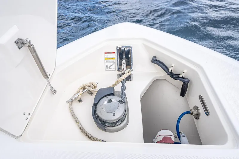 330 Boston Whaler Yacht Photos Pics 2017 Boston Whaler 330 Outrage anchor locker with rope and winch, open hatch, ocean background.