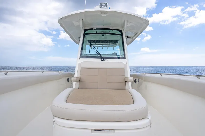 330 Boston Whaler Yacht Photos Pics 2017 Boston Whaler 330 Outrage boat with cushioned seating, ocean view, and blue sky.