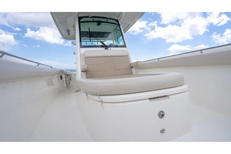 330 Boston Whaler Yacht Photos Pics 2017 Boston Whaler 330 Outrage boat interior with cushioned seating under a blue sky.