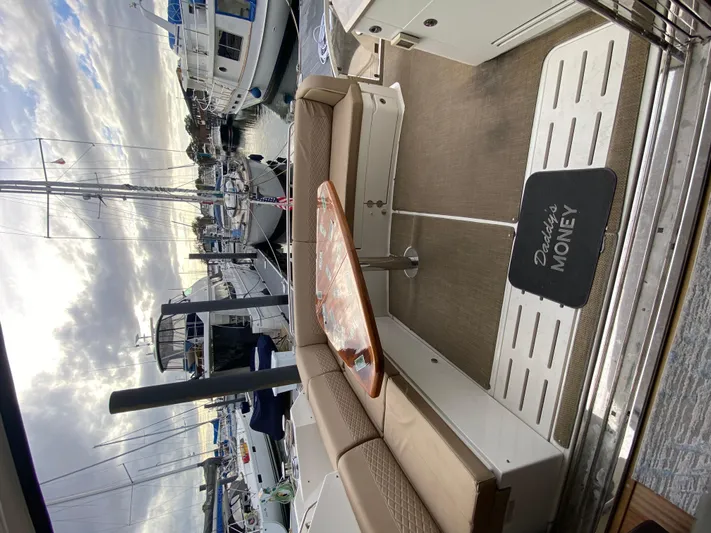 Daddy's Money Yacht Photos Pics 2017 Sea Ray L590 yacht interior with seating, table, and "Daddy's Money" mat at marina.