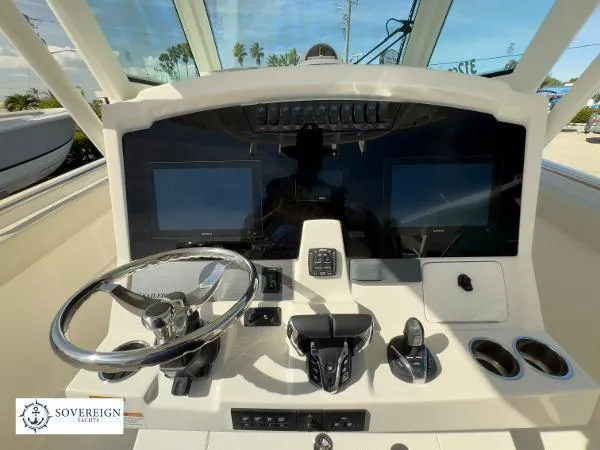 312-027 Yacht Photos Pics 2024 Sailfish 312 boat dashboard with dual screens and steering wheel.