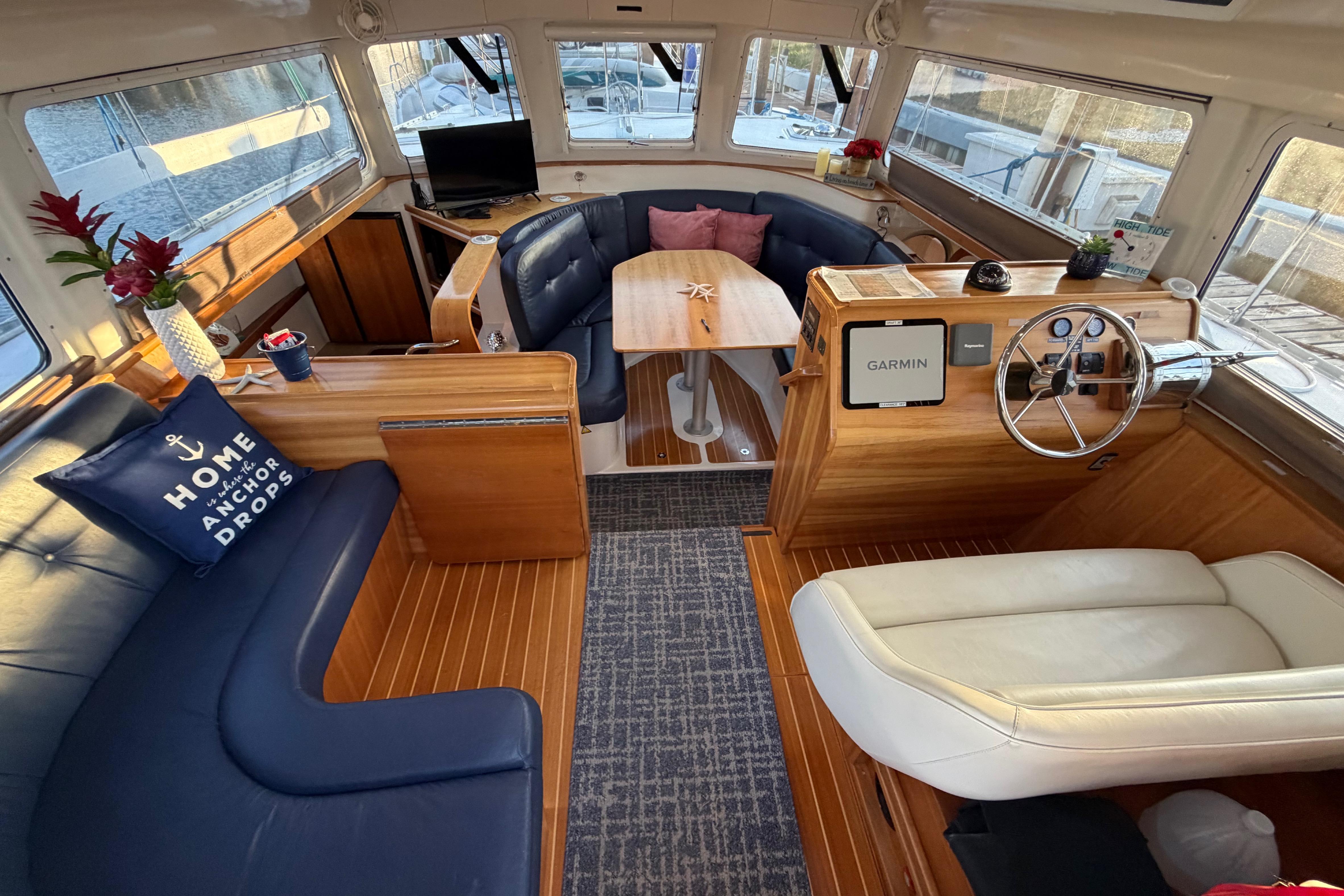Interior of 2006 PDQ PowerCat boat with cozy seating and wooden accents.
