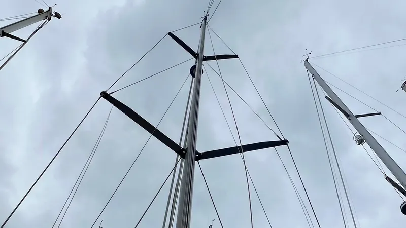 1730 Yacht Photos Pics Masts of a 1999 Beneteau Oceanis Clipper 44 CC sailboat against a cloudy sky.