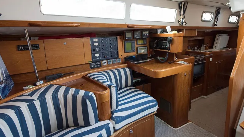 1730 Yacht Photos Pics Interior of 1999 Beneteau Oceanis Clipper 44 CC yacht with striped seating and navigation equipment.
