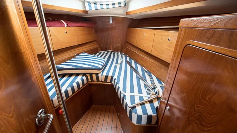 1730 Yacht Photos Pics 1999 Beneteau Oceanis Clipper 44 CC cabin with striped cushions and wooden interior.