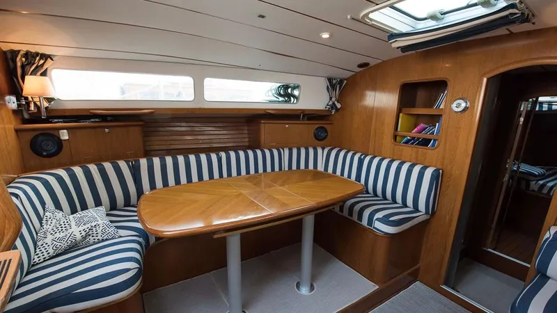 1730 Yacht Photos Pics Interior of 1999 Beneteau Oceanis Clipper 44 CC with striped seating and wooden table.