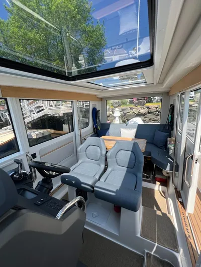 Crosswinds Yacht Photos Pics Interior of 2023 Nimbus C9 boat with modern seating and panoramic windows.