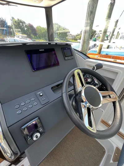 Crosswinds Yacht Photos Pics 2023 Nimbus C9 boat dashboard with steering wheel and electronic controls.