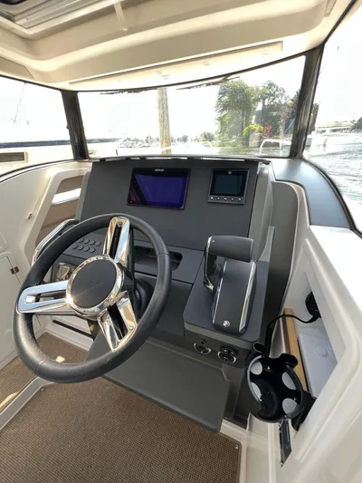 Crosswinds Yacht Photos Pics 2023 Nimbus C9 boat cockpit with modern steering wheel and navigation screens.