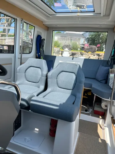 Crosswinds Yacht Photos Pics Interior of 2023 Nimbus C9 boat with blue seating and panoramic windows.