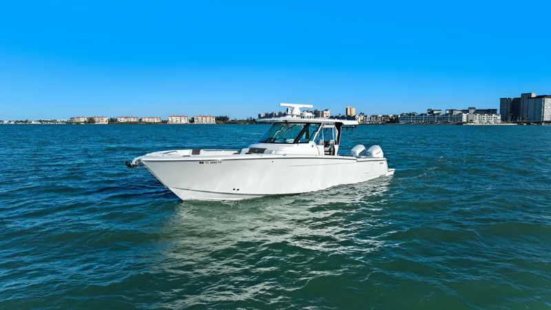  Yacht Photos Pics 2023 Bertram 39 CC boat on open water with city skyline.