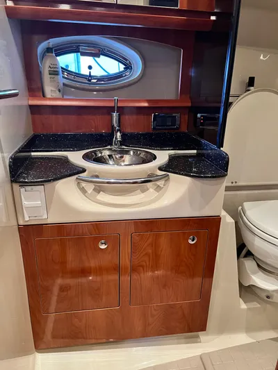 Ruby Yacht Photos Pics 2007 Four Winns 358 Vista bathroom with sink, wooden cabinets, and porthole window.