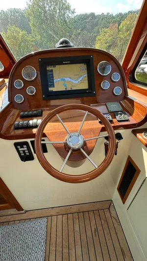 Amanti De Gaja Yacht Photos Pics Helm of 2009 Hinckley Picnic Boat 37 MKIII with navigation display and wooden steering wheel.