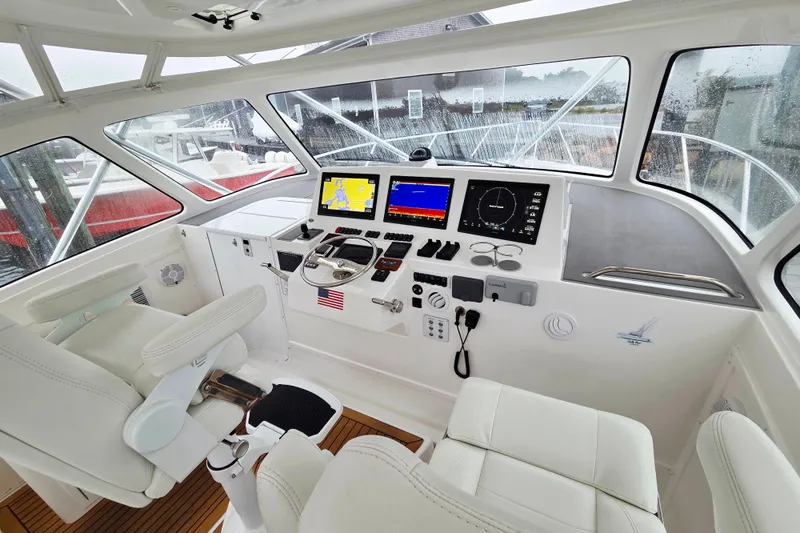 Salty Bear Yacht Photos Pics 2022 Albemarle 36 Express helm with modern navigation displays and white seating.