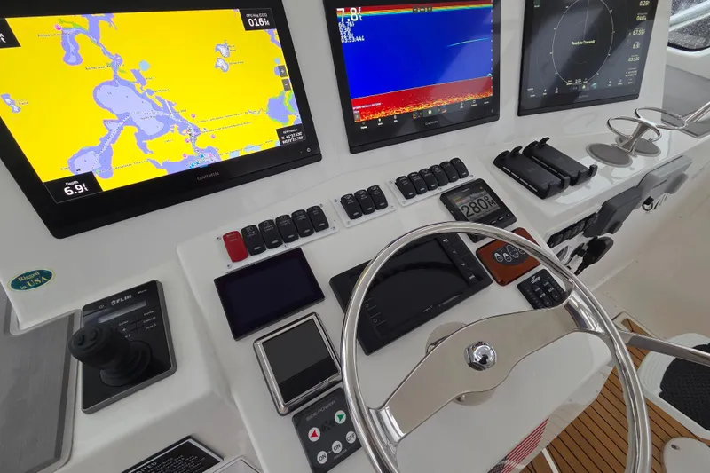 Salty Bear Yacht Photos Pics Control panel of 2022 Albemarle 36 Express boat with navigation screens and steering wheel.