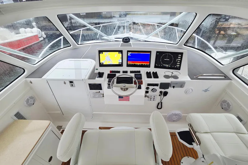 Salty Bear Yacht Photos Pics 2022 Albemarle 36 Express helm with modern navigation displays and white seating.