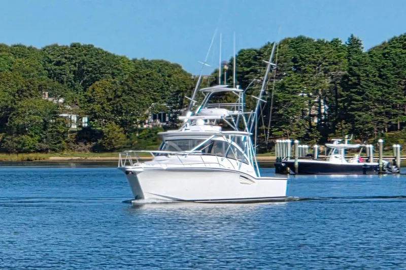 Salty Bear Yacht Photos Pics 2022 Albemarle 36 Express boat cruising on a serene lake with lush green trees.