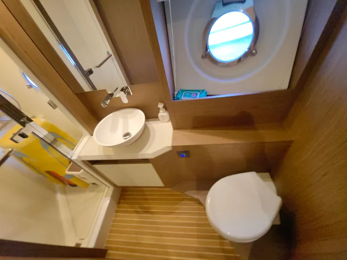  Yacht Photos Pics Modern bathroom in 2021 Monte Carlo MC6 yacht with porthole, sink, and toilet.
