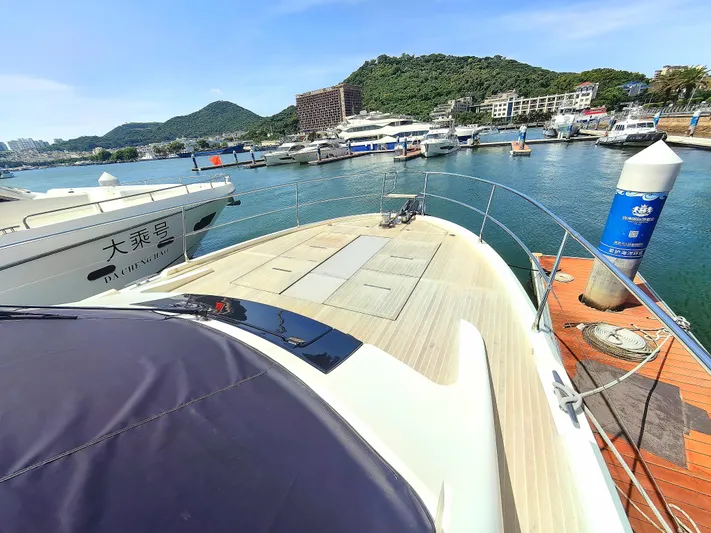  Yacht Photos Pics Luxury Monte Carlo MC6 yacht docked at marina, surrounded by scenic hills and clear blue water.