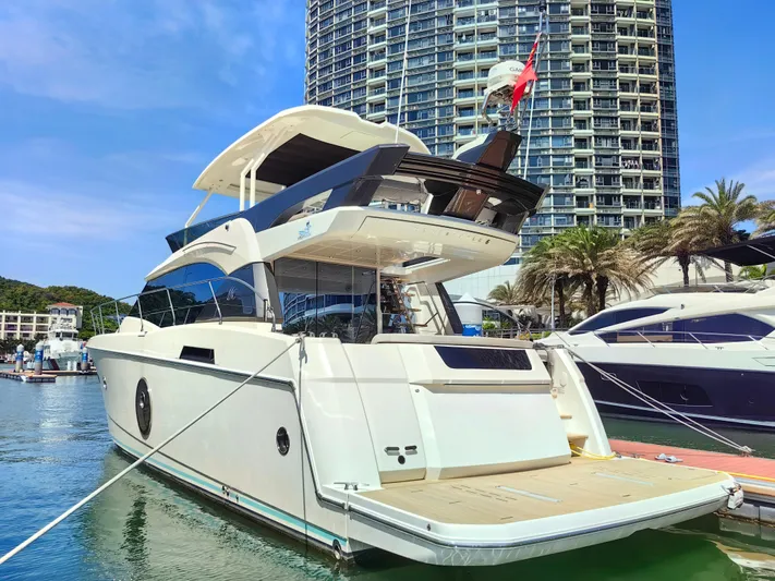  Yacht Photos Pics 2021 Monte Carlo MC6 yacht docked at marina with modern high-rise building in background.
