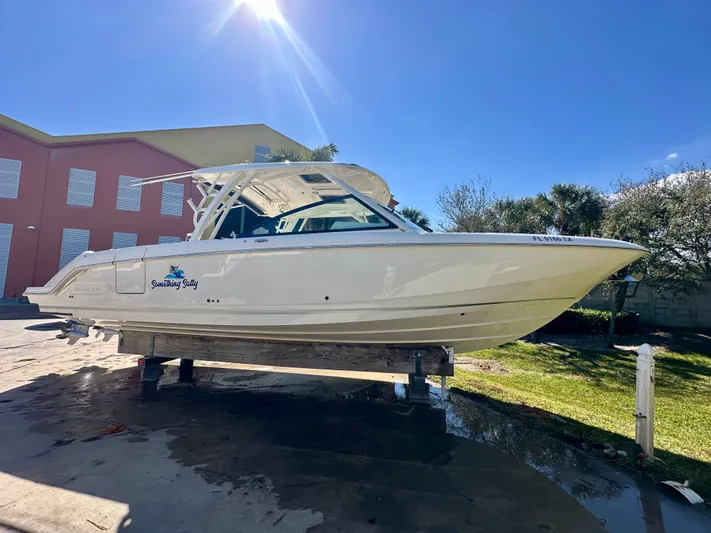  Yacht Photos Pics 2024 Boston Whaler 320 Vantage boat outdoors under sunny sky.