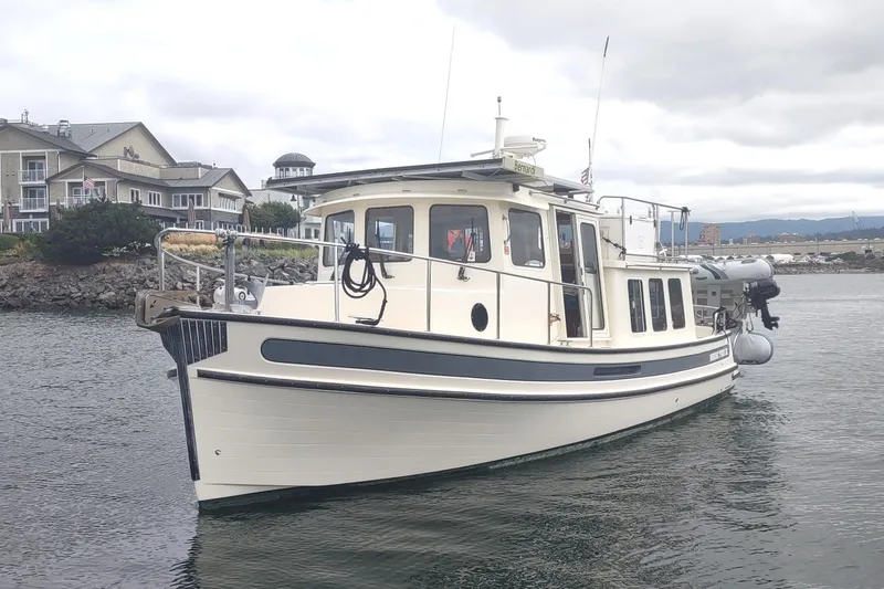 Bernardi Yacht Photos Pics 2004 Nordic Tug 32 boat on water near residential area, overcast sky.