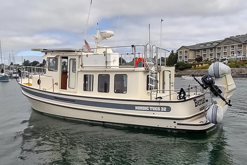 Bernardi Yacht Photos Pics 2004 Nordic Tug 32 boat docked near a waterfront hotel.