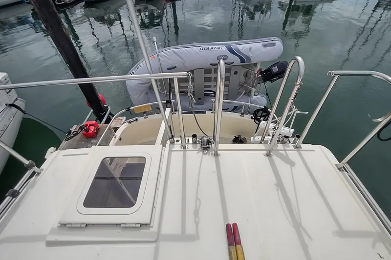 Bernardi Yacht Photos Pics Nordic Tug 32 (2004) with dinghy, docked in calm marina waters.