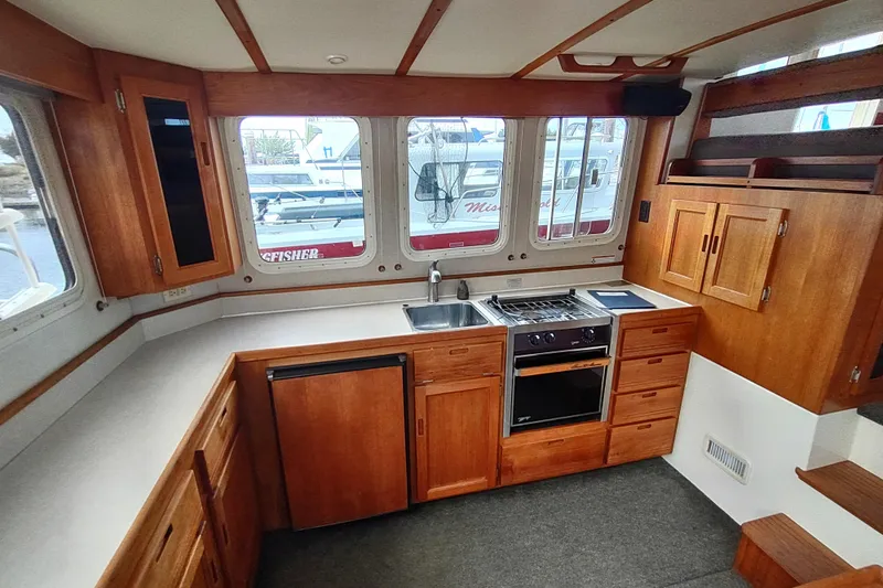 Bernardi Yacht Photos Pics 2004 Nordic Tug 32 interior kitchen with wooden cabinetry and modern appliances.